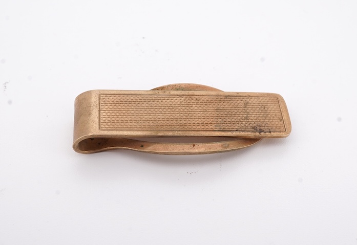 A 1980's 9ct gold tie clip, 39mm and a similar 9ct gold and black onyx set signet ring, gross weight 10 grams.